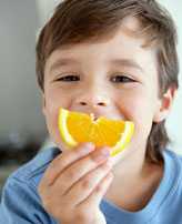 Image: petit garçon mange une orange